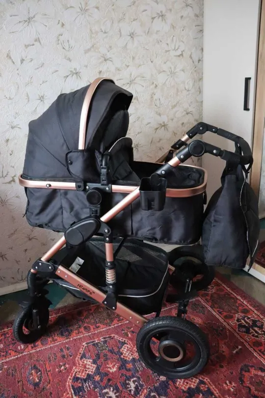 Універсальна коляска 2 в 1, яка підходить для різних умов і віку дитини. Колір моделі — чорний з глянсовою рамою. З аукціону