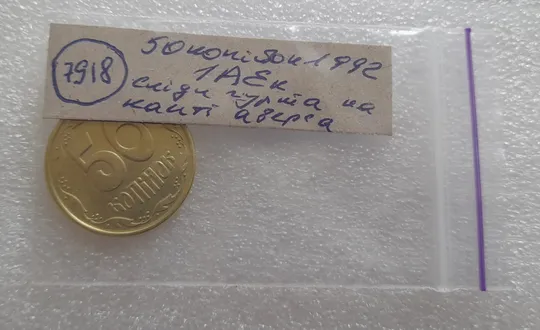 (7918) 50 копійок 1992 1АЕк сліди гурта на канті аверса + розкол від канту до щита тризуба (50 копеек 1992 след гурта, брак) Характеристики