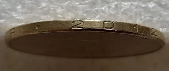 (7596) 1 гривня 2012 різновид викрошки у першій цифрі "2" слова "2012" на гурті (1 гривна 2012 брак) Продаж