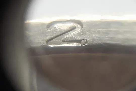 (7596) 1 гривня 2012 різновид викрошки у першій цифрі "2" слова "2012" на гурті (1 гривна 2012 брак) З аукціону