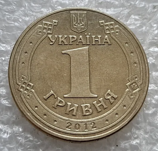 (7596) 1 гривня 2012 різновид викрошки у першій цифрі "2" слова "2012" на гурті (1 гривна 2012 брак) Недорого